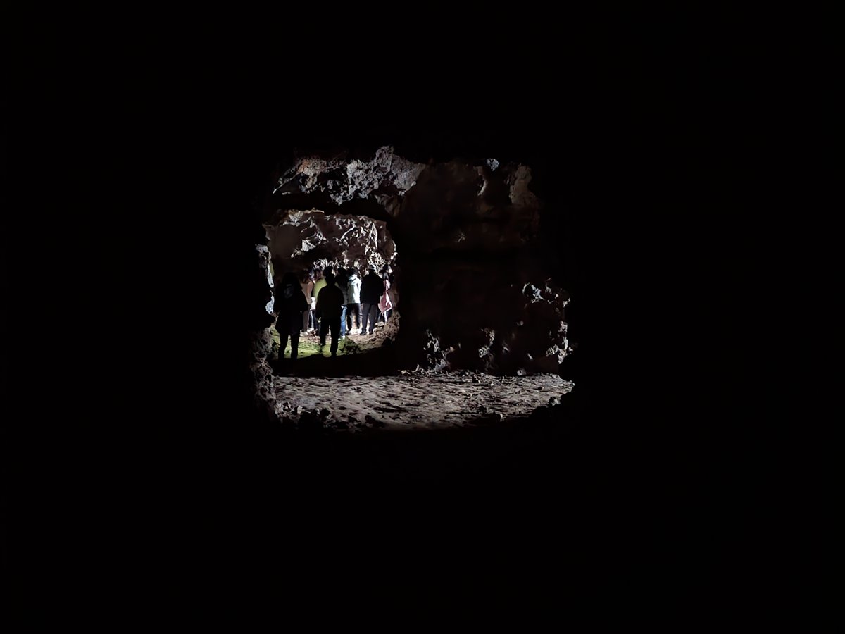 어두컴컴한 서우봉 진지동굴 내부. 기행 일행이 동굴을 따라 이동하고있다.